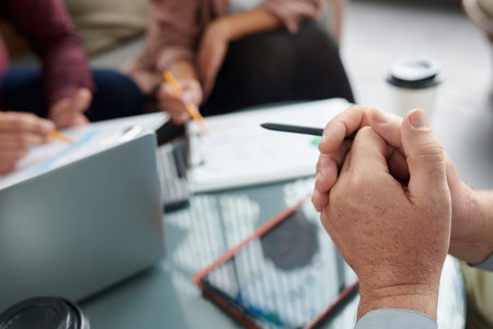 Hands of senior man attending meeting with colleagues and listening to their ideasの写真素材