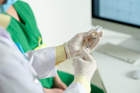 Doctor in medical grade gloves filling syringe with vaccine against dangerious covid-19 virus
