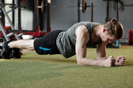 Fit strong man trying to stand in plank position as lond as possible when working on his endurance...