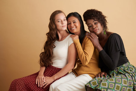 Diverse group of smiling young women leaning on back of each other