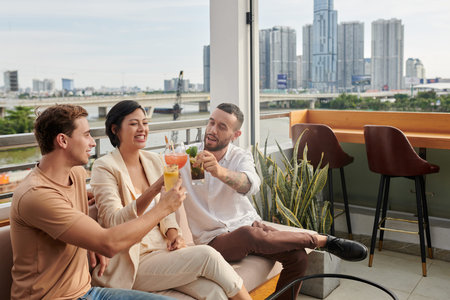 Startuppers enjoying cold drinks at rooftop bar when celebrating finishing work on big project