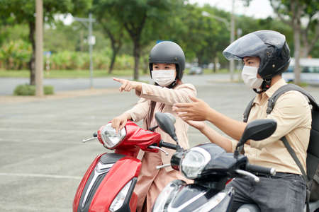 Business colleagues on scooters discussing where to spend lunch breakの写真素材