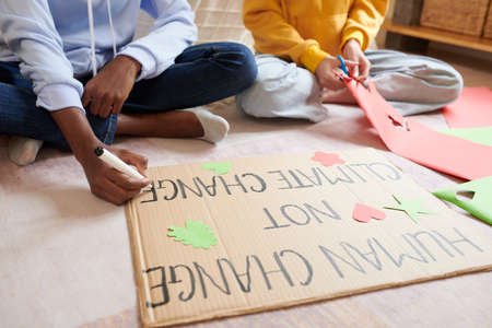 Girls decorating placard they made for climate change protestの写真素材