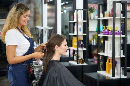 Smiling hairstylist asking customer what about her preferencesの写真素材