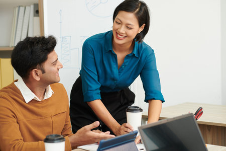 Smiling businesswoman helping new coworker to get used to work in new environmant