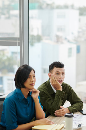 Shocked and excited business people listening to speaker talking about secret strategy that can...