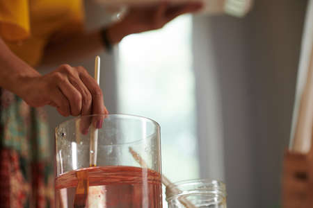 Closeup image of artist cleaning paint brush in jar of waterの写真素材