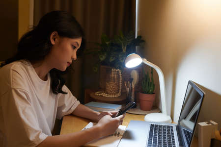 Vietnamese teenage girl using application on tablet computer when checking class scheduleの写真素材