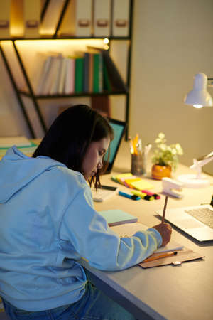 Diligent student doing homework for tomorrow class late at nightの写真素材