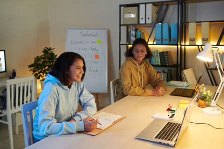Smiling students studying in common room of college dormの写真素材