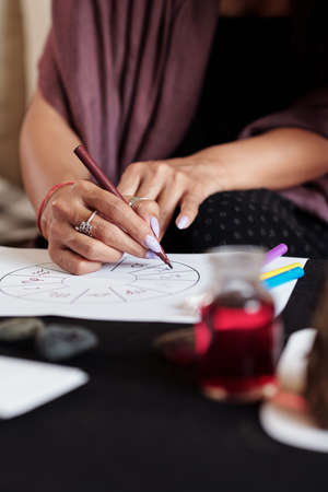 Hands of professional astrologer drawing natal card for client to shed light on personality or path in lifeの写真素材