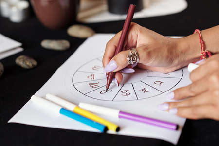 Closeup image of astrologer creating natal card for client to get answer to her questionの写真素材