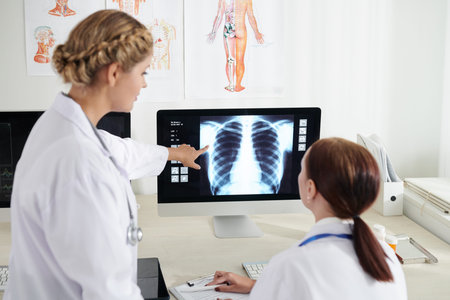 Pulmonologust and surgeon discussing chest x-ray of sick patient on computer screen