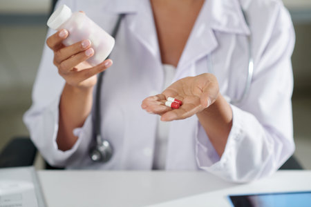 Hands of general practitioner showing new effective remedy