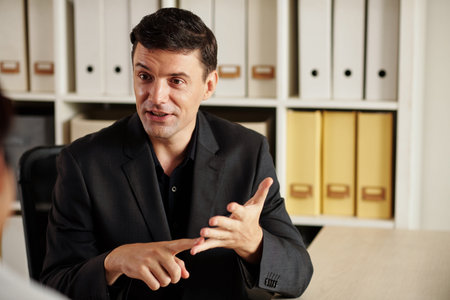 Portrait of positive businessman enumerating advantages of services his business is offering