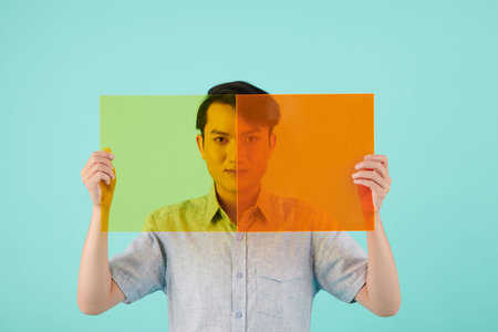 Vietnamese young man covering face with yellow and orange photo filters