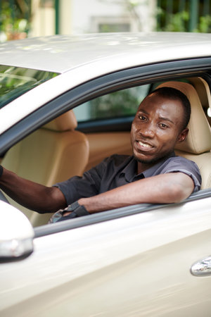 Portrait of smiling luxury car driver wearing leather gloves when drivingの写真素材
