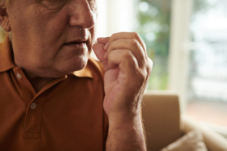 Cropped image of elderly man taking prescribed tablets to get rid of pain