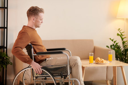 Serious young man strugging moving around in wheelchair