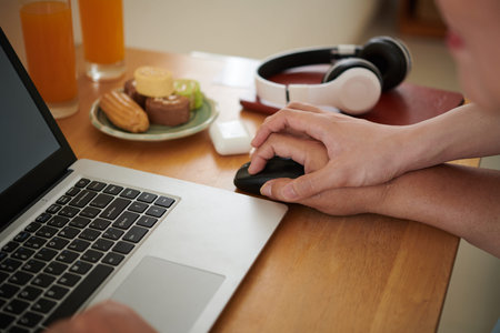 Hand of young man showing grandmother how to hold computer mouse properlyの写真素材