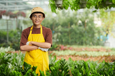 Smiling flower nursery owner enjoying his workの写真素材
