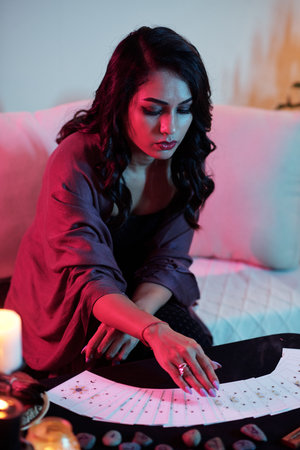 Hands of psychic flipping tarot cards on table when predicting future for clientの写真素材