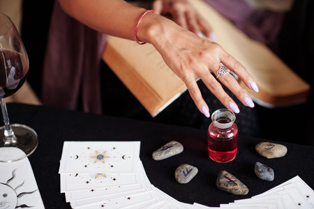 Hand of socreress casting spell over vial of love potionの写真素材