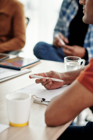 Software developer taking notes during meeting with colleagues