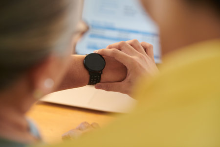 Closeup image of young man explaining grandmother how to use application on smartwatchの写真素材