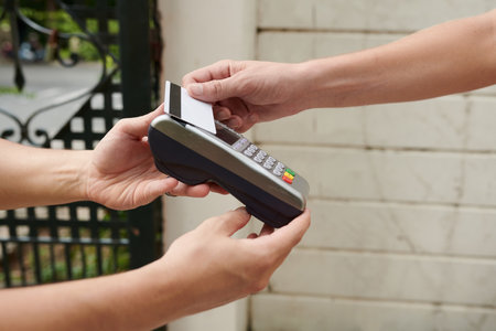 Hands of young man paying for food delivery with credit cardの素材 [FY310192832954]