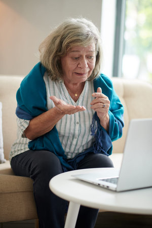 Aged woman using telemedicine service when video calling to her physician