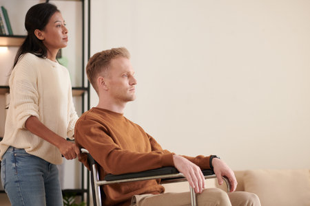 Female caregiver pushing patient sitting in wheelchairの写真素材