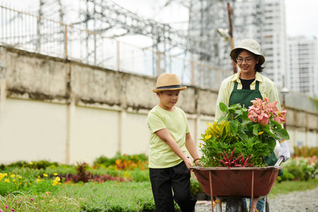 Preteen boy helping mother working at house nurseryの写真素材