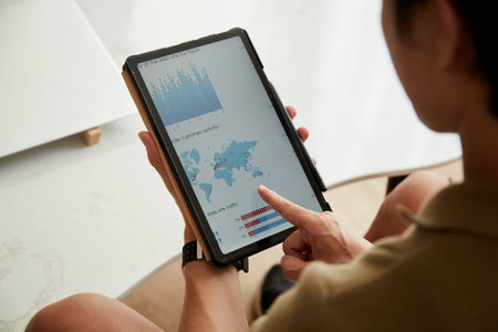 Cropped image of businessman analzying report with world map on digital tablet