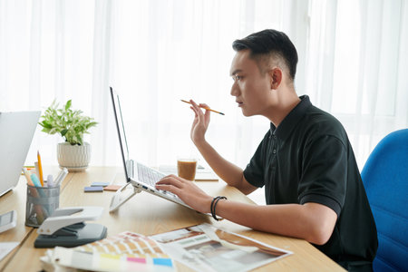 Young serious interior designer creating project for clientの写真素材