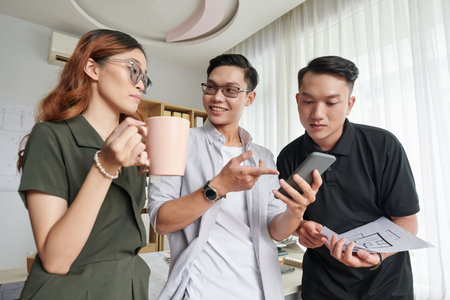 Coworkers discussing new funny short video during coffee break