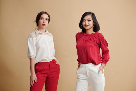 Portrait of fashion models demonstrating clothes in front of camera at studio