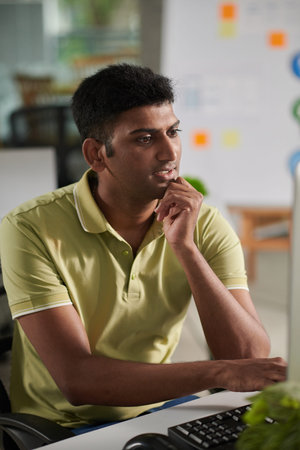 Portrait of lead UX designer checking layouts created by his colleagues