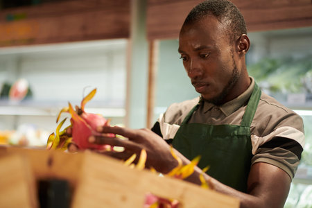 Grocery store worker checking if dragon fruits are rotten or not