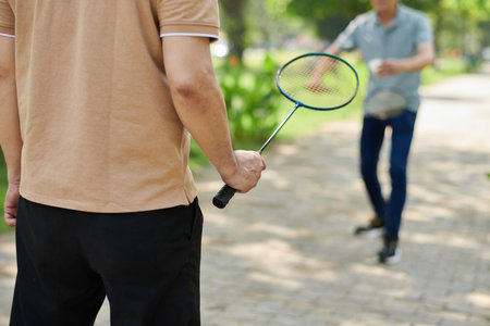 Cropped image of senior man playing badminton with his adult sonの写真素材