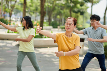 Senior woman exercising outdoors with her familyの写真素材