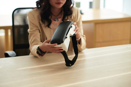 Businesswoman wearing virtual reality headset to have online meeting with colleagues