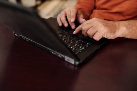 Hands of senior man working on laptop