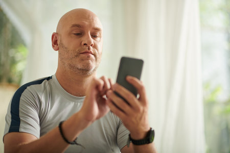 Mature man answering text message from friend or family memberの写真素材