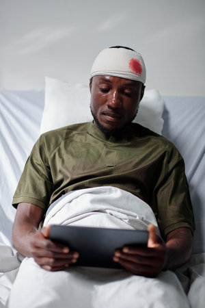 Military man with head injury watching video on tablet computerの写真素材