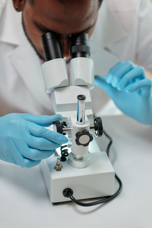 Researcher working with microscope in medical officeの写真素材