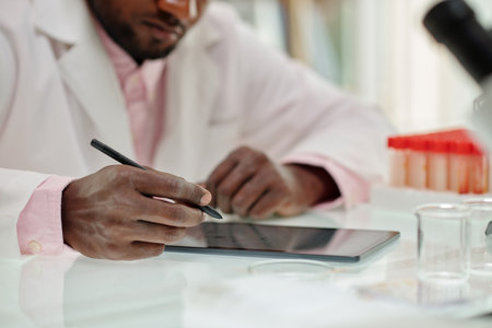 Scientist filling form on tablet computer after finishing work on big reseachの写真素材