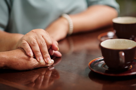 Senior woman touching hand of her husband, expressing love and supportの写真素材