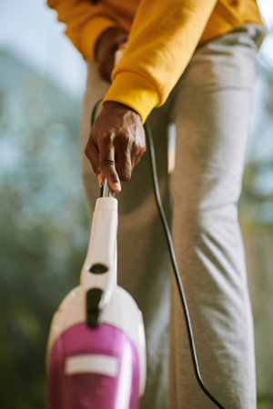 Young woman vacuum cleaning apartment floorの写真素材