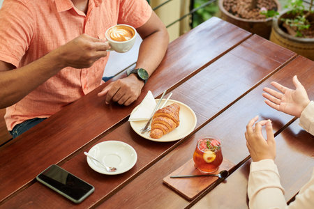 Friends meeting in cafe to have some drinks and discuss news